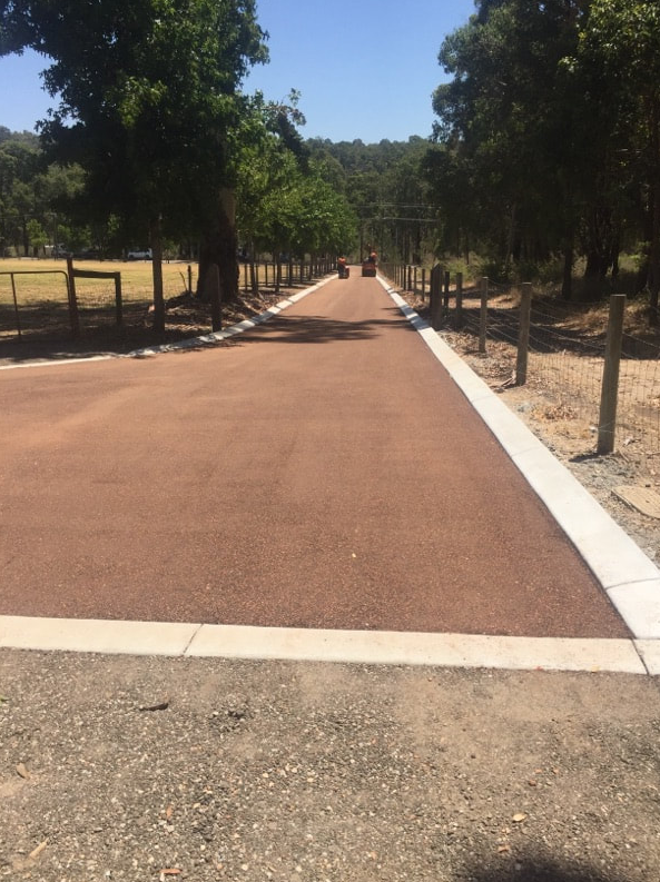 This is a photo of a hot spray & seal bitumen roadway which is in the process of being installed by Dandenong South Road Tech